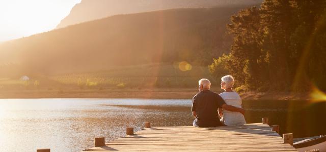Retired Couple Sitting on a Dock by the Lake